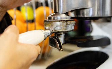 Barista attaching portafilter to espresso machine.