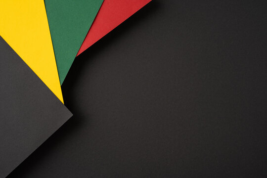 Abstract arrangement of vibrant colored papers against a black backdrop, ideal for designs