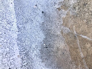 Rough textured concrete floor with white paint spills, for background