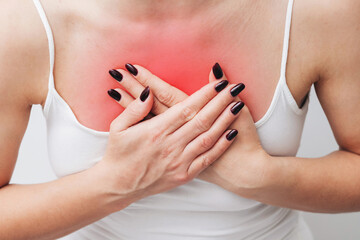 Heart attack background. Woman holding her chest in pain. Experiencing heart attack symptoms. Sharp...