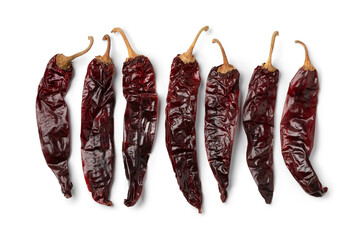 Dried Mexican guajillo chili peppers in a row isolated on white background close up