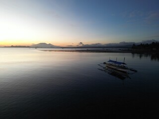 Traditional Filipino Boat at Sunrise with Mountain Backdrop