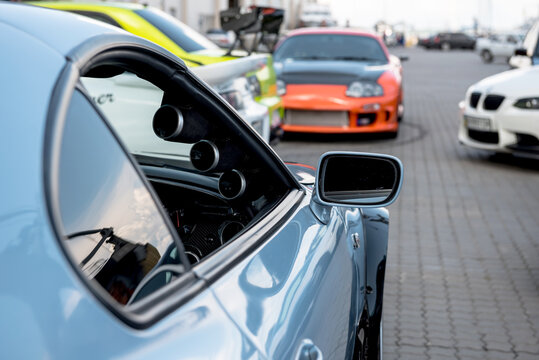 Tuned car meet - modified cars owners gathering: blue, white and orange Toyota Supras; lime Green Mitsubishi Lancer Evo and white BMW M3. Odesa, Ukraine - May 07 2016.