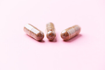 Siberian ginseng (Eleutherococcus senticosus) capsules on bright background. Soft focus. Close up. Copy space.