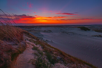 The breathtaking view of a stunning sunset over a tranquil and serene dunes landscape