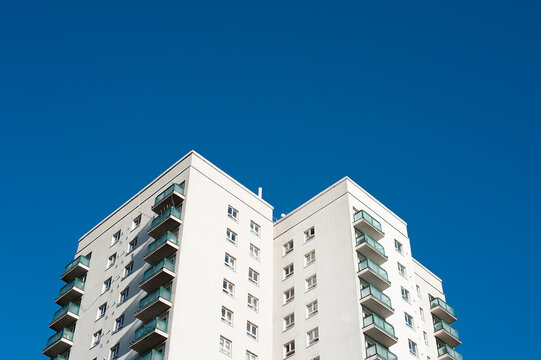 Low angle view of a high rise residential apartment block against a clear blue sky.