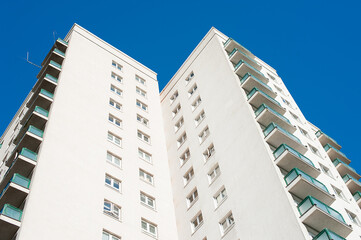 Low angle view of a high rise residential apartment block against a clear blue sky.