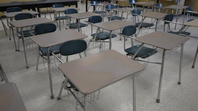 Desks fill the empty classroom, showcasing the anticipation of learning and education in a quiet school environment set for a new day.