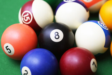Pool ball game on a green billiard table. Playing snooker and billiards with cue. Number 8 ball in middleNumbered ball background. Fun sports environment.  Entertainment backdrop