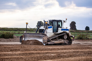 Fototapeta premium Crawler dozer against the background of sky. Construction equipment. Bulldozer at work. Bulldozer. Construction Site. Earthmover. Earthworks.