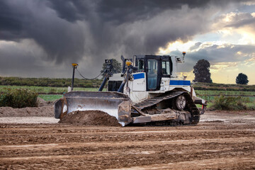 Fototapeta premium Crawler dozer against the background of sky. Construction equipment. Bulldozer at work. Bulldozer. Construction Site. Earthmover. Earthworks.