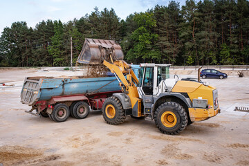 WWheel front loader at a construction site in a quarry. Powerful modern equipment for earthworks. Construction site. Heavy wheel loader at work.