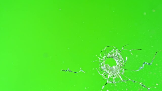 Super slow motion of gunshot through the glass, shattering against green screen background . Filmed on high speed cinema camera, 1000 fps.