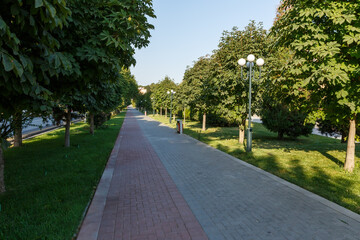 Haji Muin Shukrulla Park walkway lined with trees in Samarkand, Uzbekistan during sunny weather