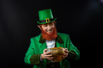 Leprechaun elf on St. Patrick's Day. Cheerful character Irish leprechaun for advertising with a red...