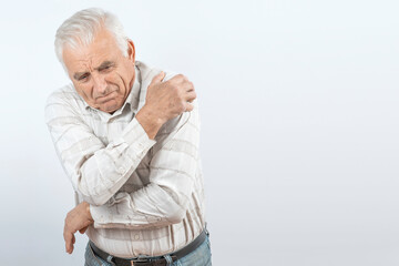 Arthritis symptoms, suffering from pain. The hands of the senior man massage a painful elbow. Inflamed male joint, stiffness of movement. Old age, health. Close up view..