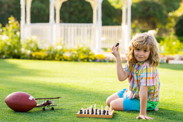 Dream kids and childhood concept. Kid shows chess pieces on a chessboard. Clever concentrated and...