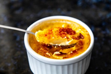 Crème brûlée, creme brule. Classic creme brulé being flambé. Burning, flaming, ramekins, vanilla beans, blowtorch, sugar
