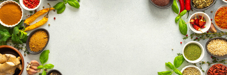 Colorful, fresh herbs and spices framing a gray background, a perfect natural border to bring attention to culinary creativity, top view and copy space, banner