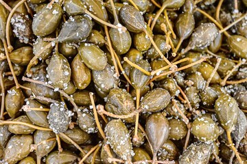 Close-up of salted capers in vibrant green hues, highlighting their natural texture and culinary appeal, perfect for Mediterranean and gourmet food concepts.