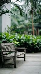 Obraz premium Relaxing garden area features a wooden bench and concrete table surrounded by greenery and scattered leaves for a peaceful retreat