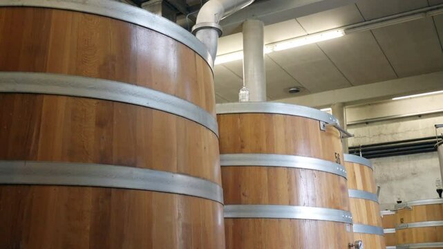 Wine casks with marked numbers on the surface on winemaking factory, wood barrels for wine storage, winemaking industry