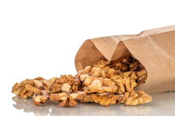 Shelled walnuts with paper bag, close-up, isolated on white background.