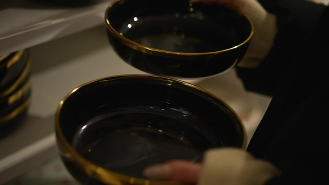 A girl chooses plates for her kitchen.
The girl buys dishes.
Dishes for a stylish kitchen.
Designer handmade tableware.
Coatware, black.
Black poud