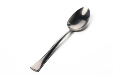 Elegant stainless steel spoon resting on a white surface with a subtle shine captured in soft light
