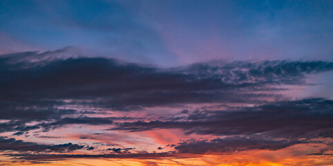Sunrise sky background. Dramatic scenery sunset. Sky with clouds in Sunrise sky light background. Sunrise with clouds in various shapes. Calm Sunrise sky and sun through clouds over.