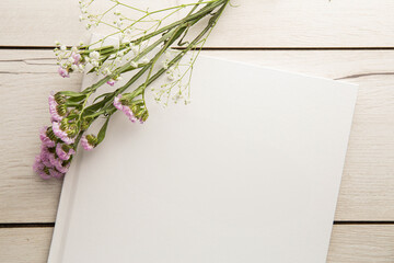 Flatlay of a blank book or photo album with flowers for mockup