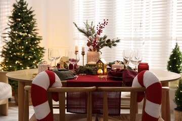 Christmas table setting with stylish dishware and festive decor indoors