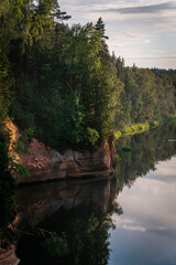 eagle cliffs near Cēsis on a sunny summer evening after rain with a reflection in the river.