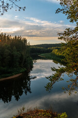 Obraz premium eagle cliffs near Cēsis on a sunny summer evening after rain with a reflection in the river.