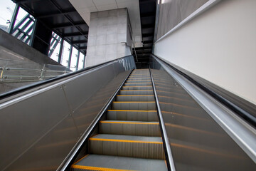 An escalator featuring bright yellow steps that move both upward and downward