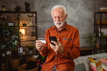 senior mature man buy online on cellphone with credit card at home