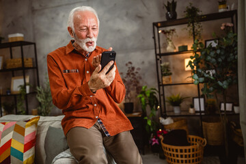 senior man welcoming have video call on mobile phone at home