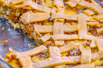 Close-up of a lattice pie with a slice removed, revealing its caramelized filling and flaky crust. Perfect for food photography, culinary blogs, recipe books, or dessert advertisements.