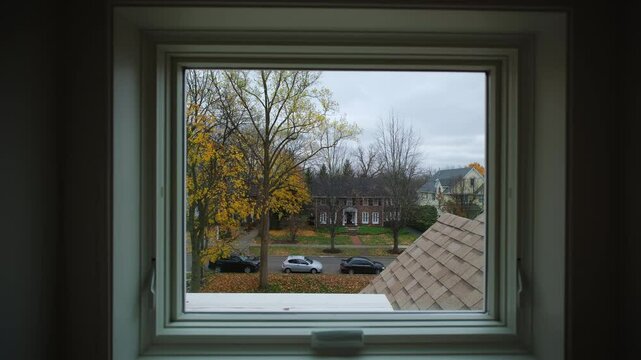 The window in the room overlooks an autumn backyard with autumn leaves on a tree, Autumn, fall season. Move camera