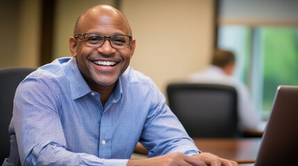 Smiling Businessman Working on Laptop in Office