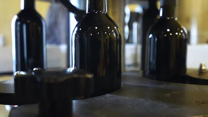 Red wine bottles on moving conveyor belt, process of sealing bottles with cork and labelling before distribution, automated bottling conveyor, red wine bottles preparation concept