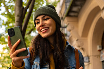 A young woman reading updates on her phone as she explores the city's streets