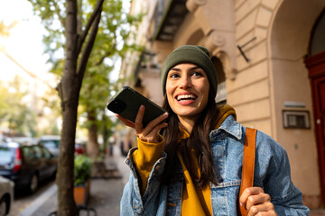 A young woman sending a voice message while exploring the city