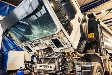 Crashed truck with crashed and demolished windshield at repair center with no people.