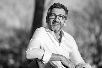 Black and white portrait of a seated man outdoors