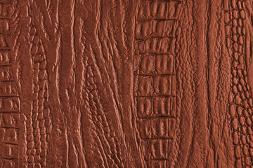 Crocodile genuine leather structure texture macro, orange colored leatherette surface with metallic, pearlescent effect. Reptile skin close up, macro background, wallpaper, backdrop