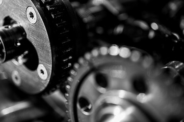 Black and white close-up of metal gears and mechanical parts symbolizing industrial equipment, precision engineering and mechanical processes, selective focus