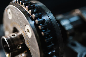 Close-up view of industrial metal gears in motion, symbolizing engineering, machine building, machine construction and precision manufacturing, disassembled car engine, spare parts. Selective focus