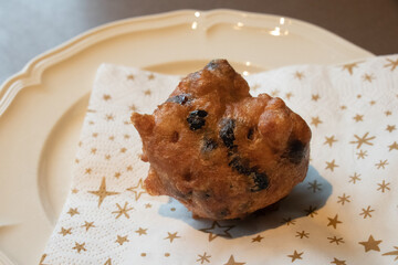 Oliebol fresh Dutch pastry on plate festive tissue. New years treat in the Netherlands. Happy New Year snack.