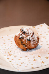 Oliebol fresh Dutch pastry on plate festive tissue. New years treat in the Netherlands. Happy New Year snack.
